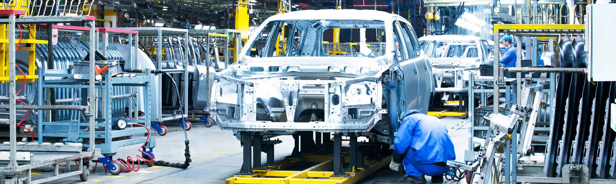 Automotive production line with material-handling racks around vehicle bodies